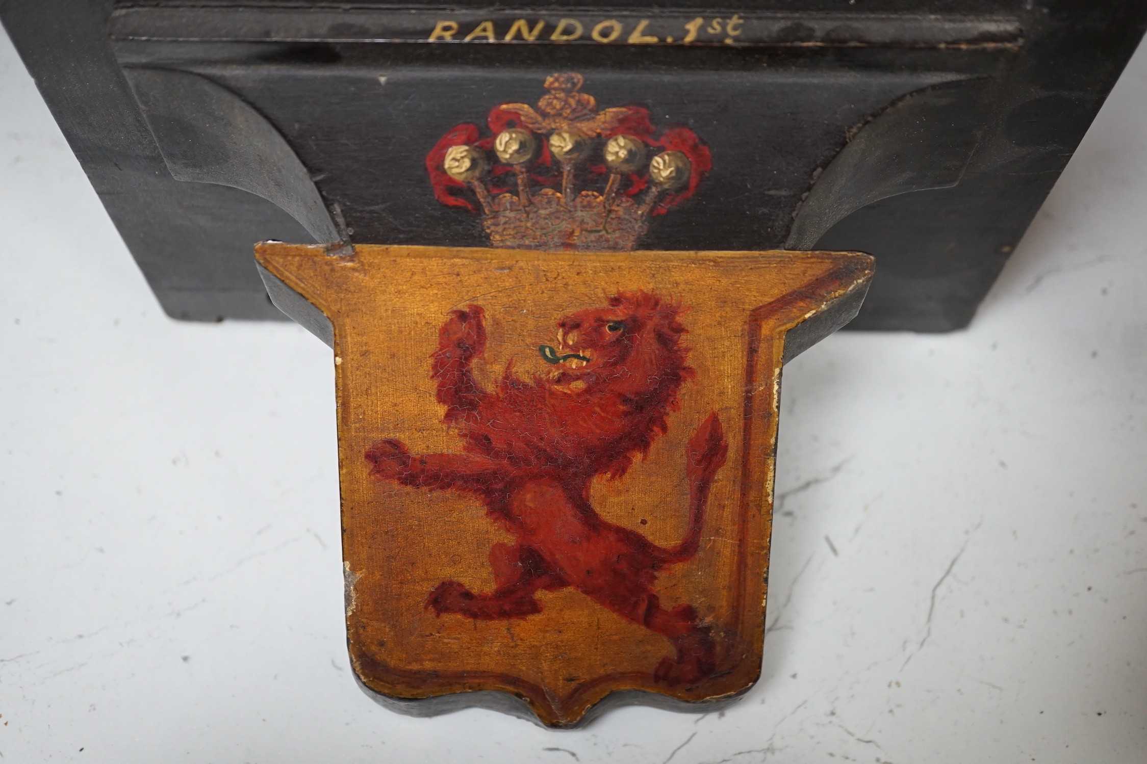 Four 19th century painted and ebonised heraldic wall brackets together with a 19th century armorial plaque